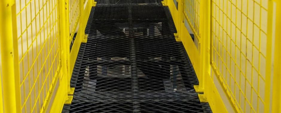 Yellow safety fence and black expanded metal grating sidewalk
