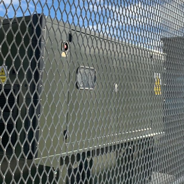 Expanded metal security fence is installed along the perimeter of the military facilities.