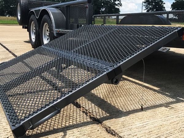 Black expanded metal trailer ramps are installed on the trailer.