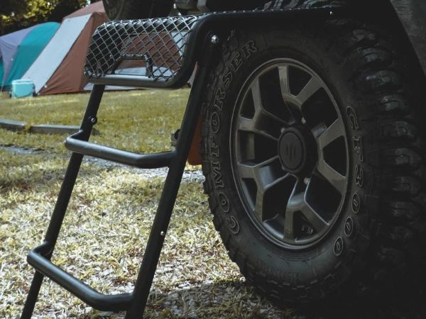 Black expanded metal multi-function car step ladder is placed next to the truck.