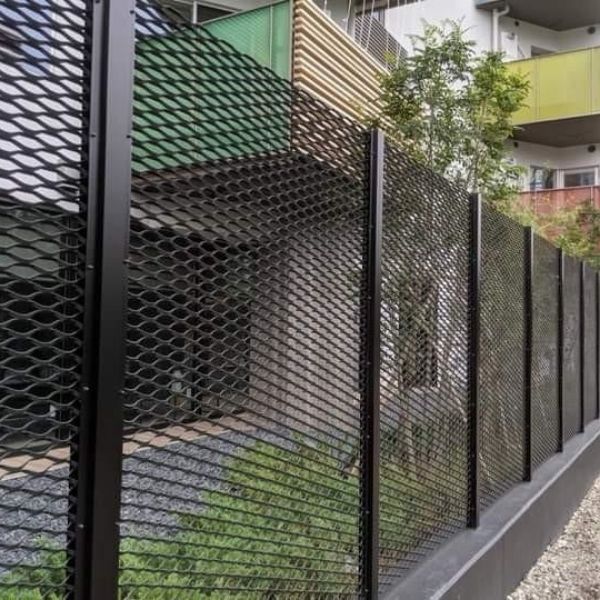 Black expanded metal security fence is installed along the residential community.