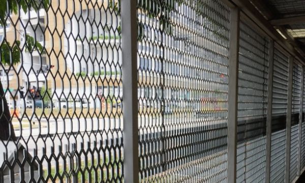 Road and buildings are seen clearly from the hexagonal expanded metal fence openings.